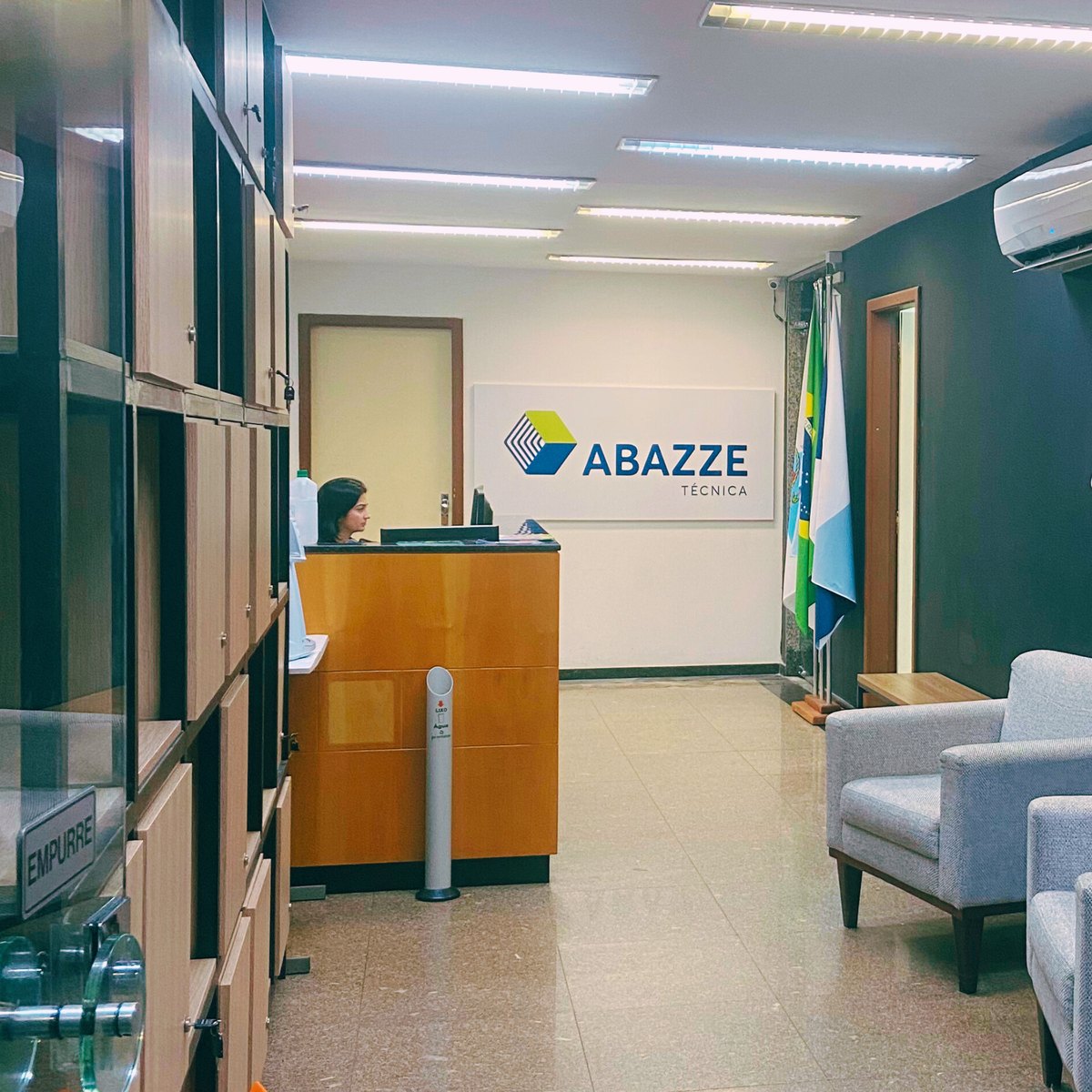 Recepção da Abazze Técnica, em Alcântara, São Gonçalo: balcão de atendimento, letreiro da escola na parede e sala de espera